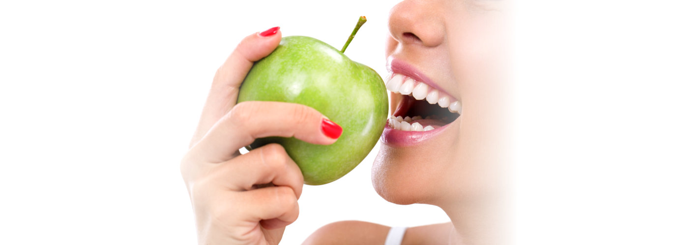 Closeup of the face of a woman eating a green apple